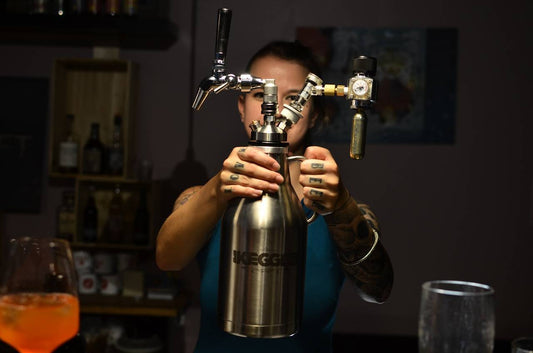 Beer growlers: the ultimate guide 2023 image of girl holding steel growler in front of her face with tattooed hands